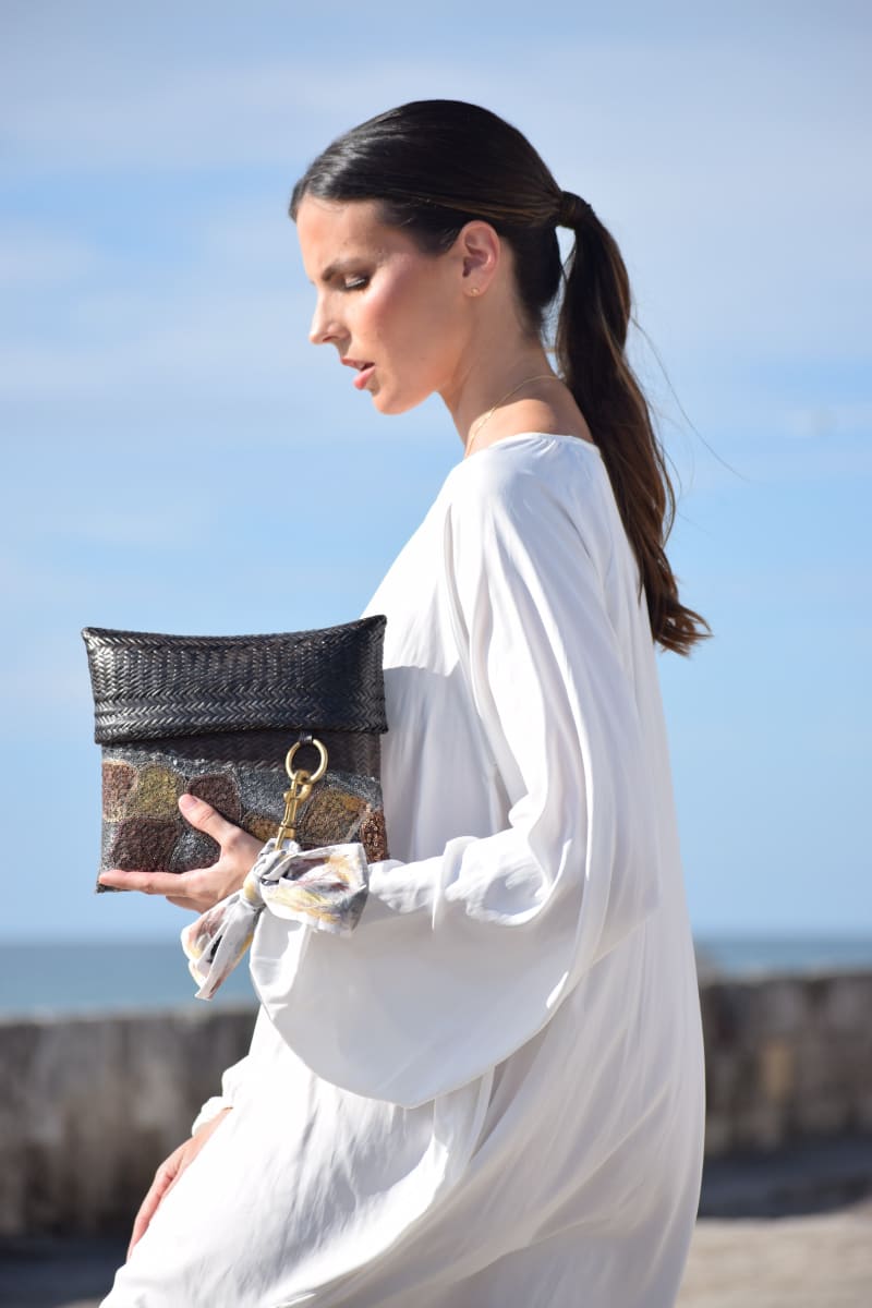 woman on the walls of cartagena carrying a guaviare envelope created by Claudia Akel