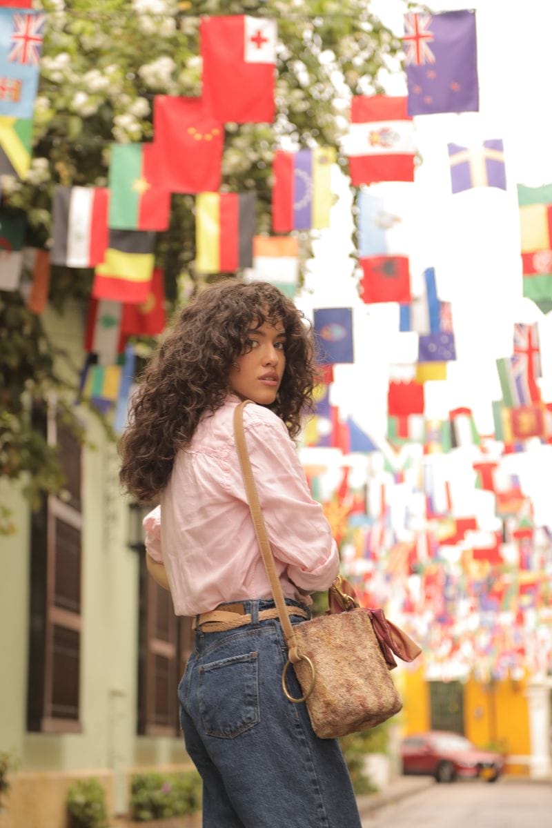 Model on a street in Cartagena de Indias, with Claudia Akel handbag
